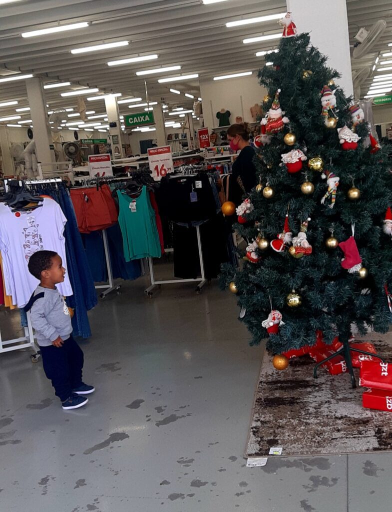 O encantamento de uma criança diante de uma árvore de Natal