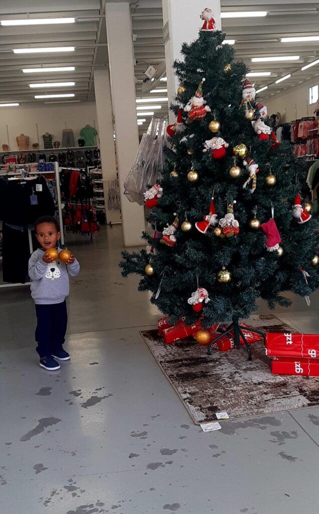 O encantamento de uma criança diante de uma árvore de Natal