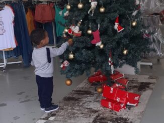 O encantamento de uma criança diante de uma árvore de Natal