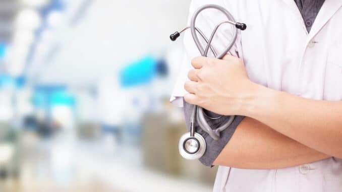 Doctor with a stethoscope in the hands and hospital background