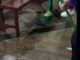 Fieis tirando água que inundou o piso da igreja
